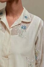 Off white cotton Chanderi short shirt-kurta set with all-over blue & beige hand block printed appliqué flowers, highlighted with sequins and multi-coloured beads.