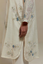 Off white cotton Chanderi short kurta set with all-over blue & beige hand block printed appliqué, highlighted with sequins and multi coloured beads.
