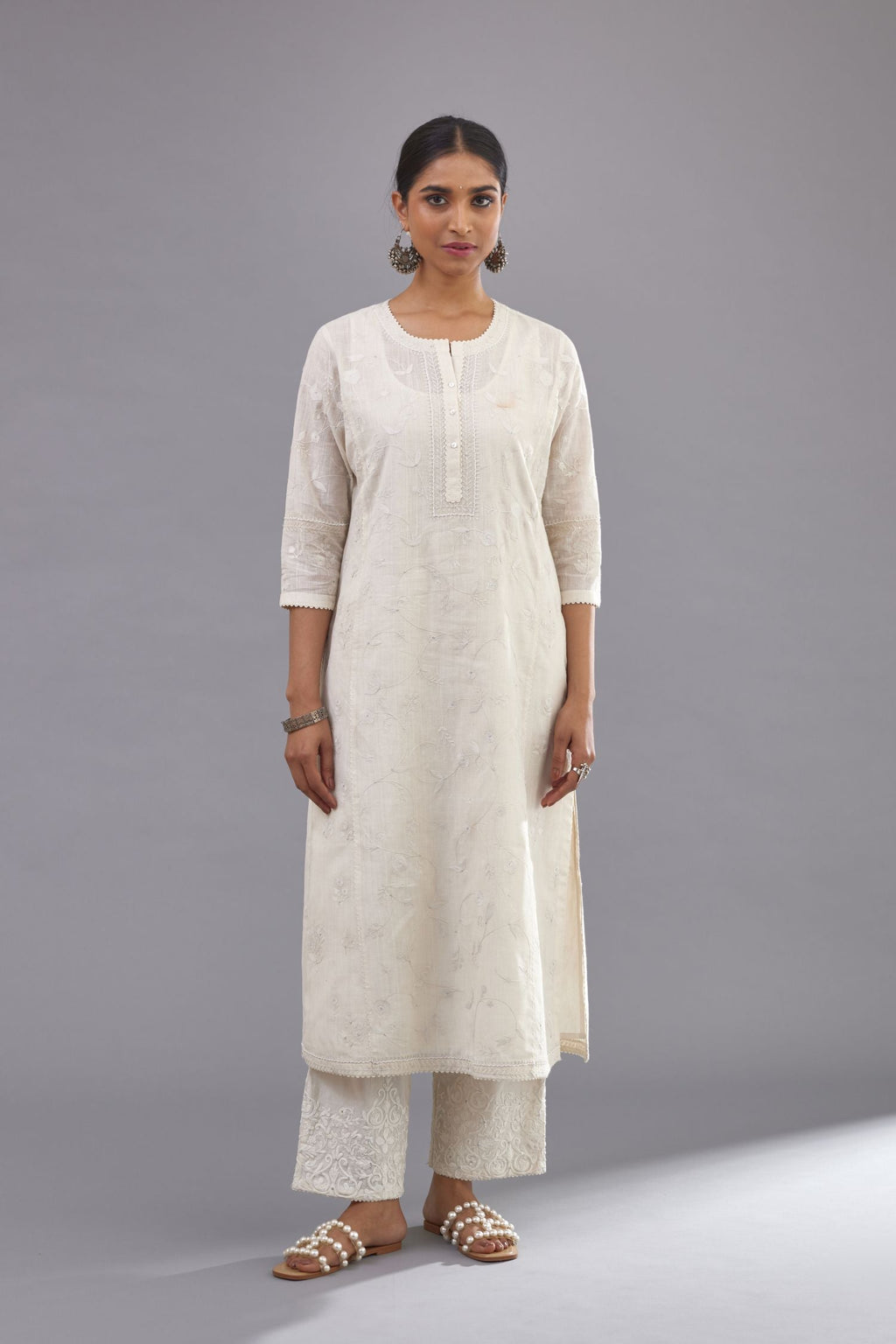 Off-white Handspun handwoven cotton kurta with all-over jaal embroidery and small assorted flowers embroidery at side panells, highlighted with sequins handwork.