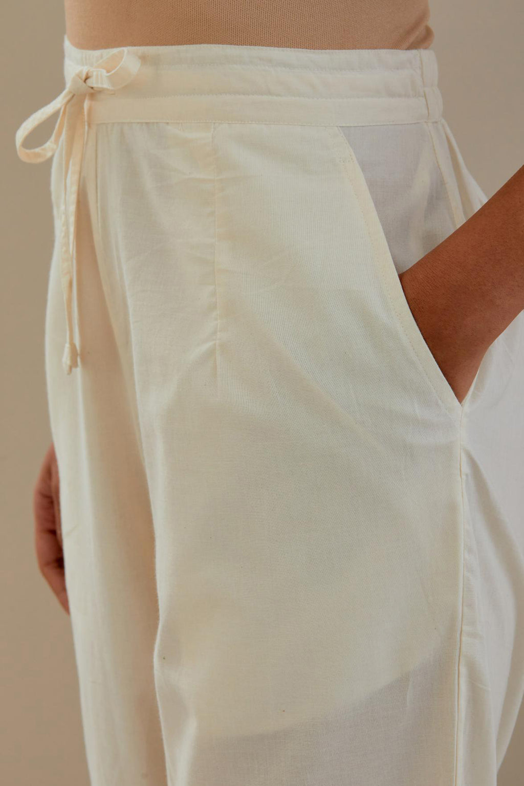 Off white straight pants detailed with applique work at bottom.