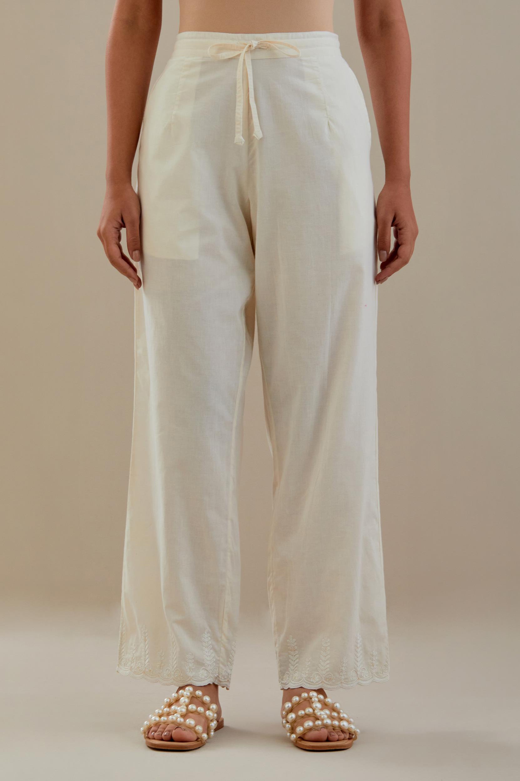 Off white cotton straight pants with off white dori embroidery at hem, highlighted with sequins work. 