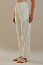Off white cotton straight pants with off white dori embroidery at hem, highlighted with sequins work. 