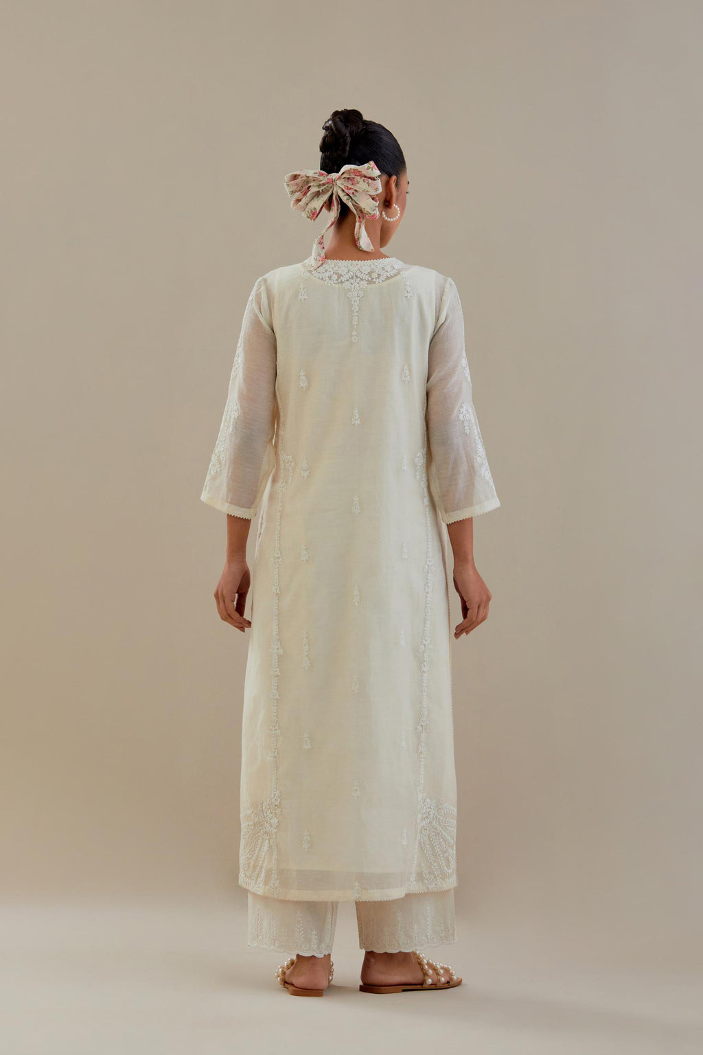 Off white cotton chanderi straight kurta set with button placket neckline, highlighted with all-over off white dori embroidery, paired with off white cotton strai. 