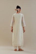 Off white cotton chanderi straight kurta set with button placket neckline, highlighted with all-over off white dori embroidery, paired with off white cotton strai. 