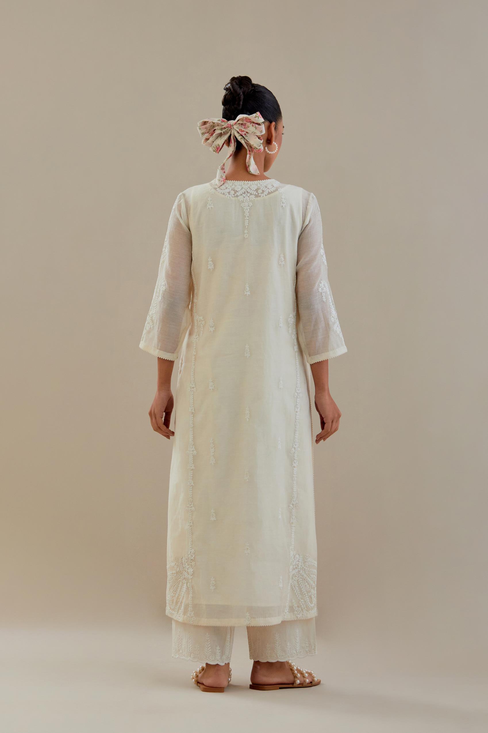 Off white cotton chanderi straight kurta set with button placket neckline, highlighted with all-over off white dori embroidery, paired with off white cotton strai. 