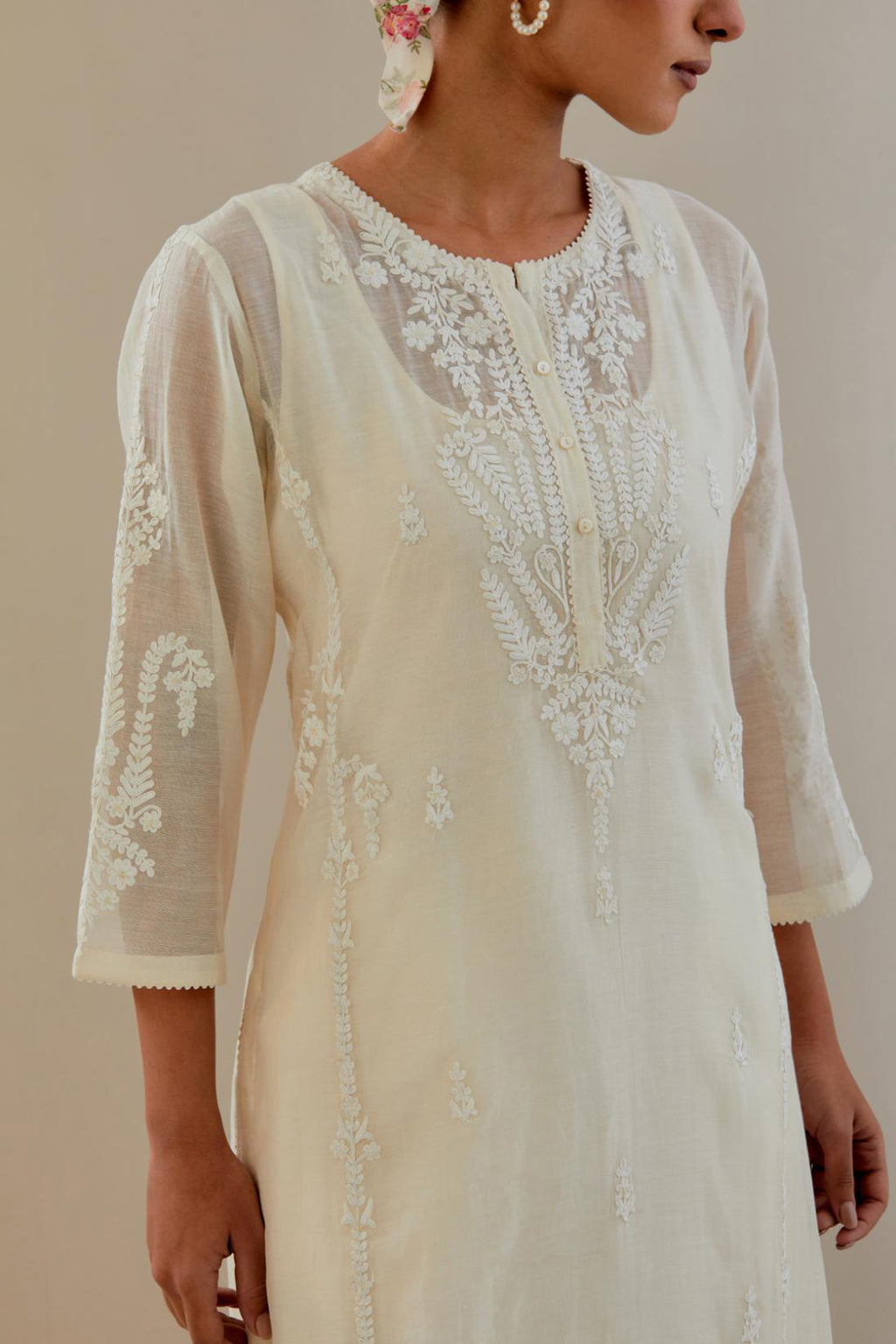 Off white cotton chanderi straight kurta set with button placket neckline, highlighted with all-over off white dori embroidery, paired with off white cotton strai. 