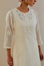 Off white cotton chanderi straight kurta set with button placket neckline, highlighted with all-over off white dori embroidery, paired with off white cotton strai. 
