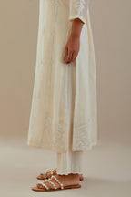 Off white cotton chanderi straight kurta set with button placket neckline, highlighted with all-over off white dori embroidery, paired with off white cotton strai. 