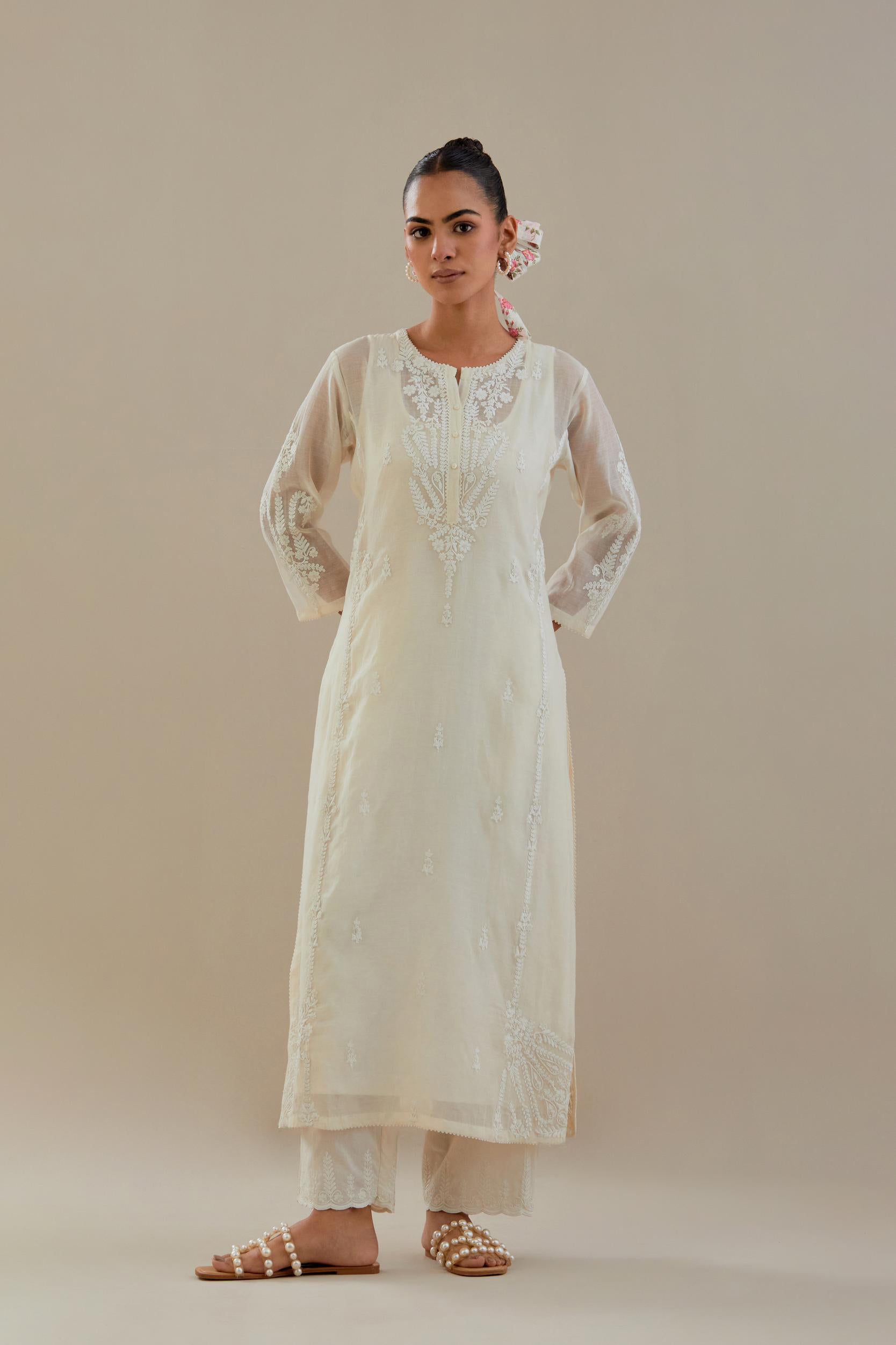 Off white cotton chanderi straight kurta set with button placket neckline, highlighted with all-over off white dori embroidery, paired with off white cotton strai. 