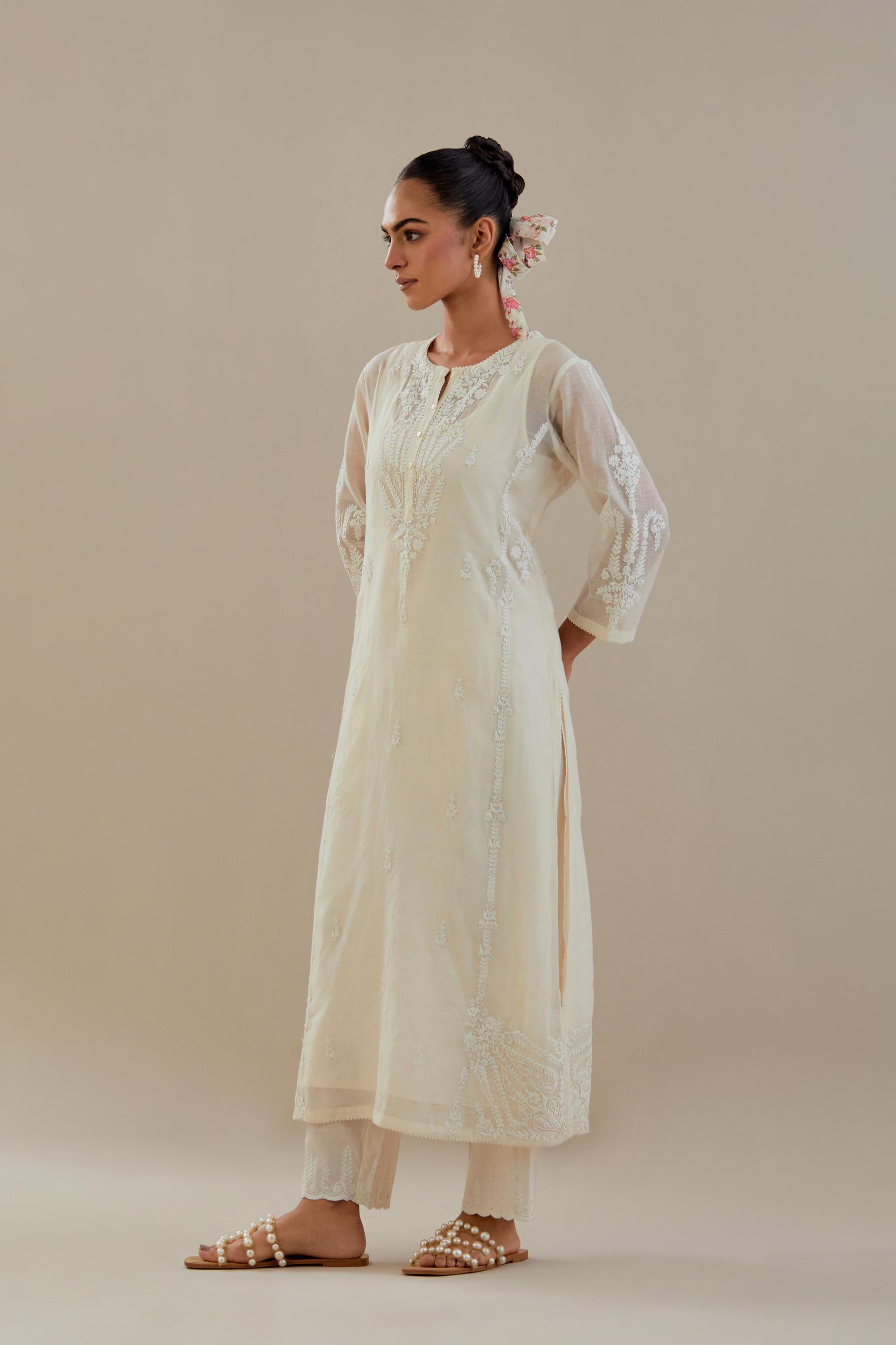 Off white cotton chanderi straight kurta set with button placket neckline, highlighted with all-over off white dori embroidery, paired with off white cotton strai. 