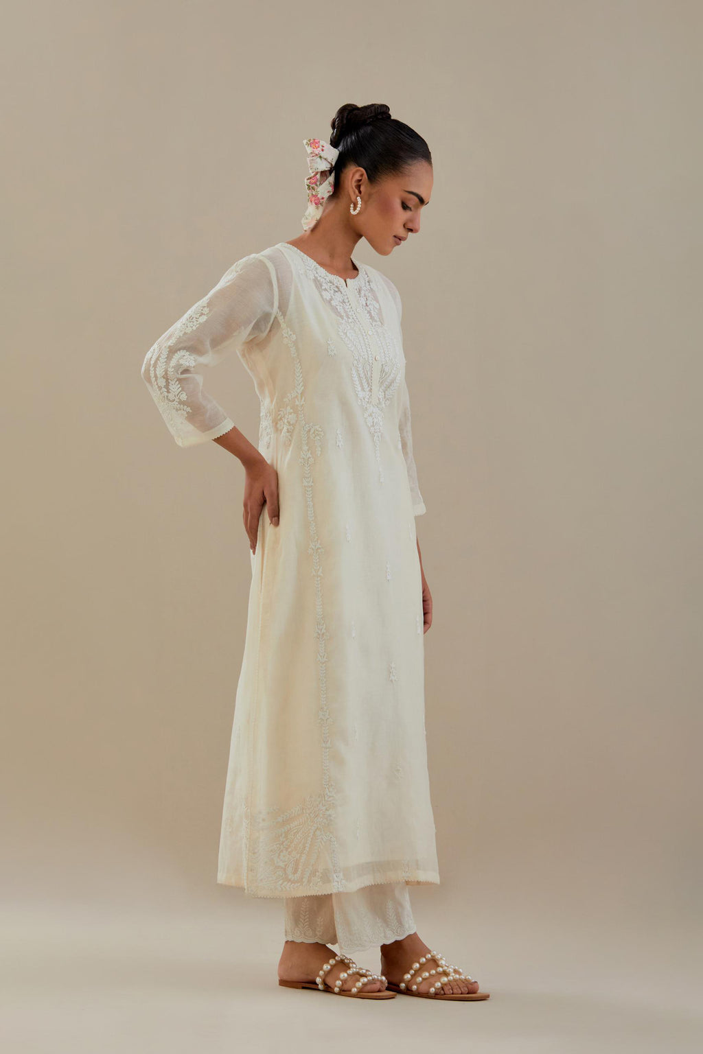 Off white cotton chanderi straight kurta set with button placket neckline, highlighted with all-over off white dori embroidery, paired with off white cotton strai. 