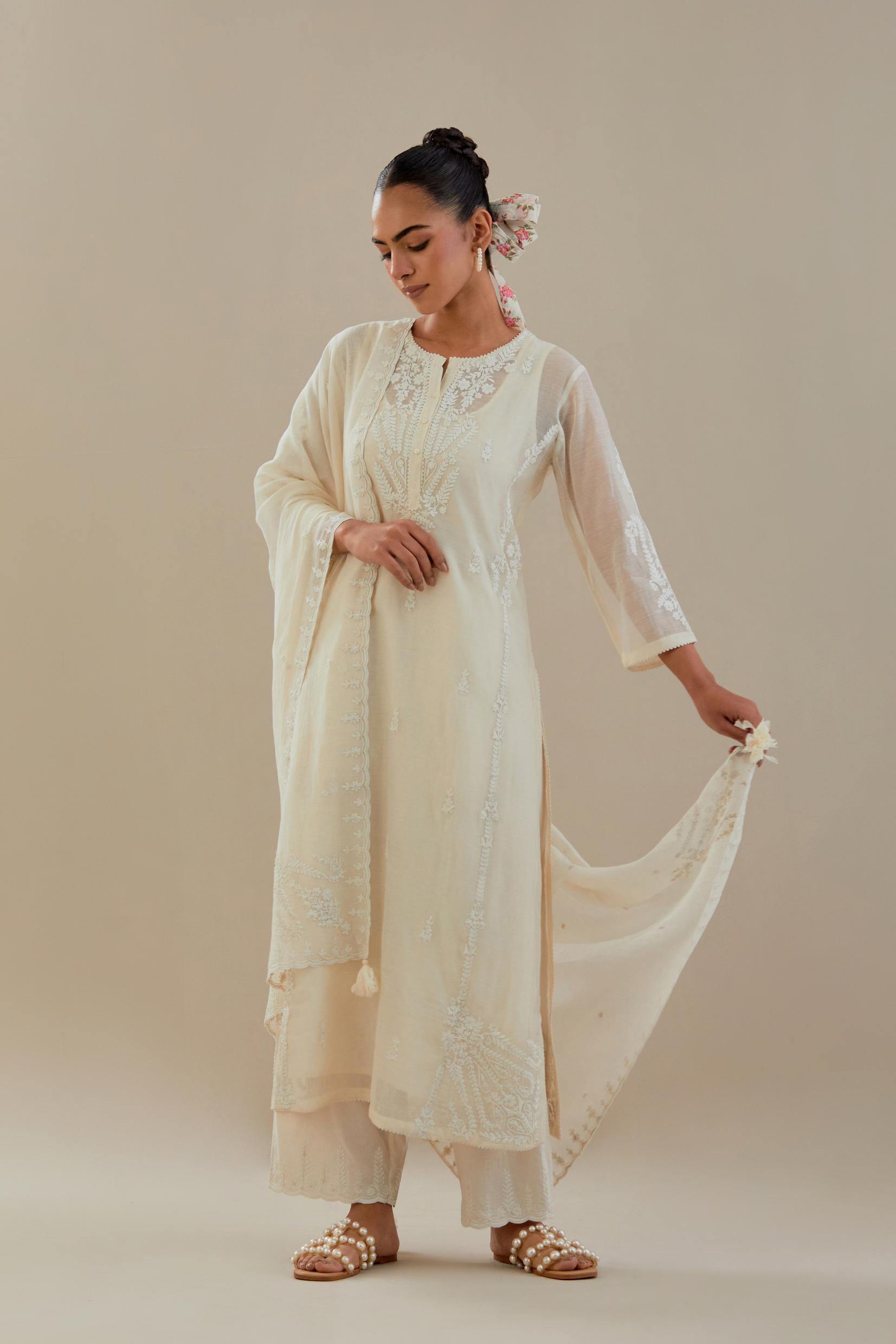 Off white cotton chanderi straight kurta set with button placket neckline, highlighted with all-over off white dori embroidery, paired with off white cotton strai. 