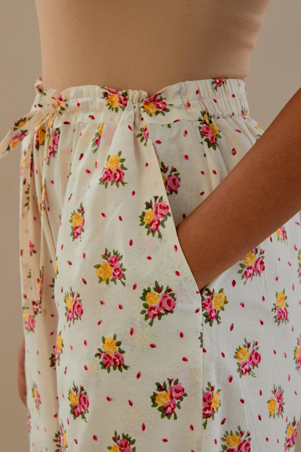 Off white cotton straight pants with all-over small multi colored hand block print, detailed with applique work at bottom.
