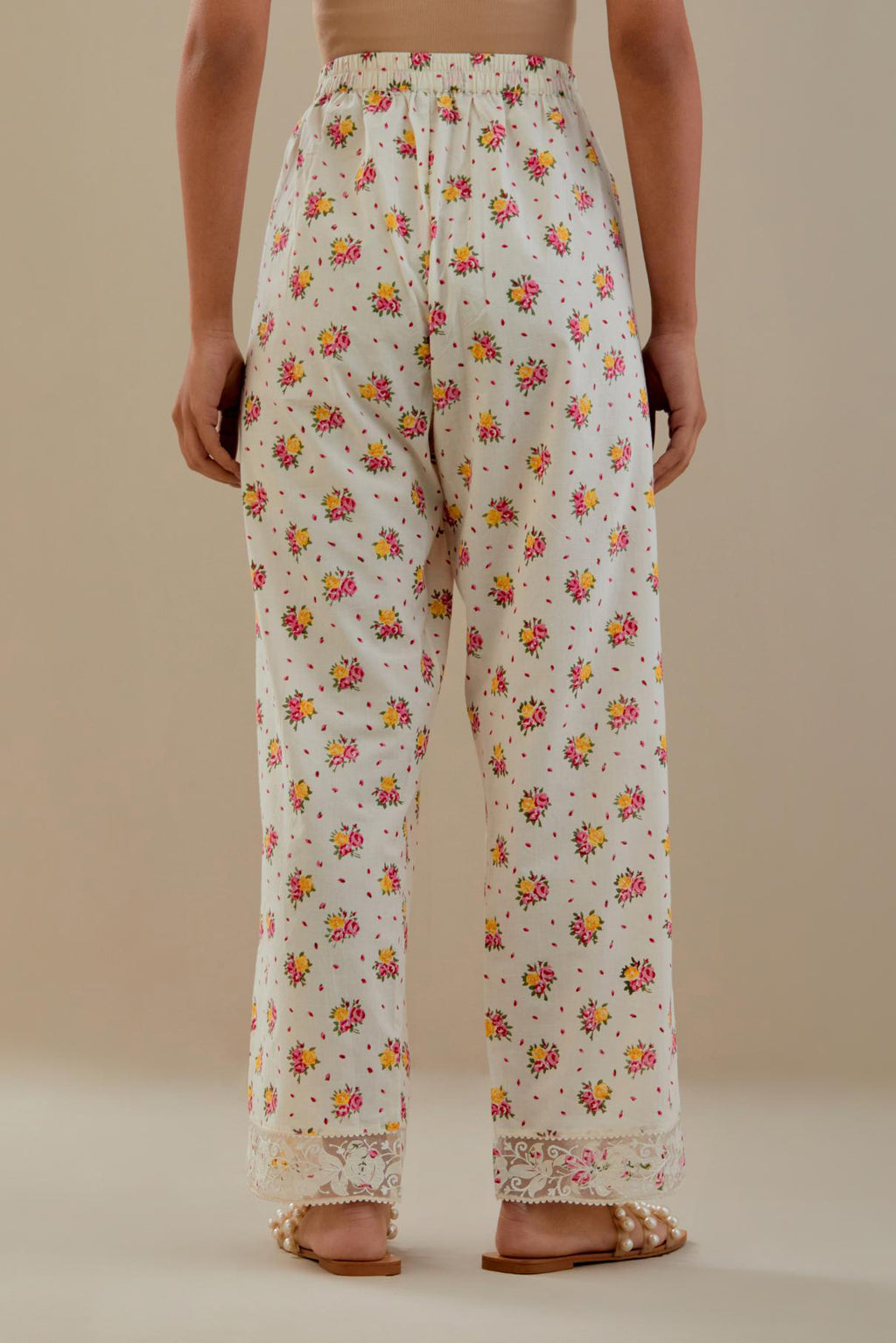 Off white cotton straight pants with all-over small multi colored hand block print, detailed with applique work at bottom.