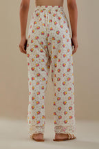 Off white cotton straight pants with all-over small multi colored hand block print, detailed with applique work at bottom.