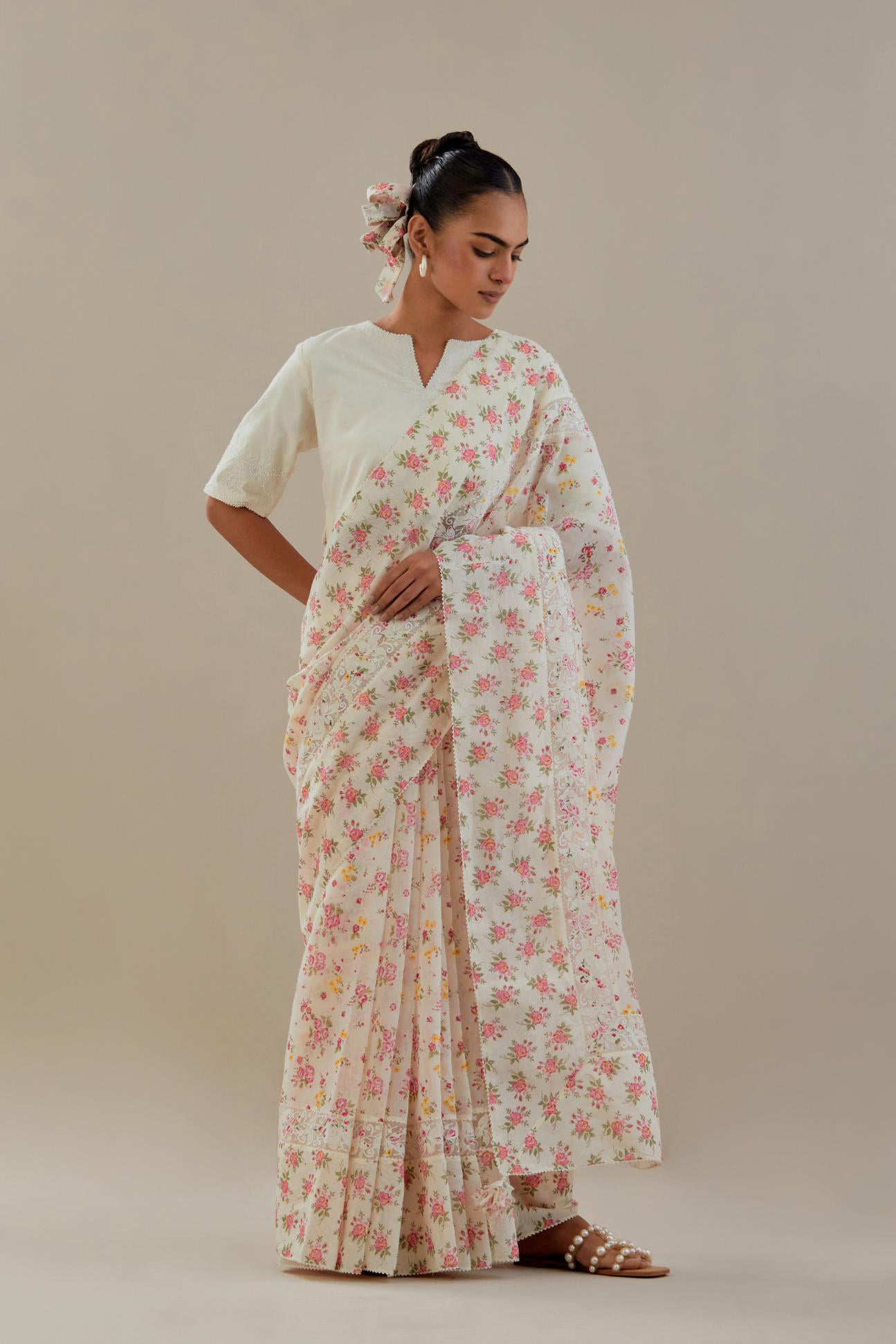 Off white cotton chanderi saree, highlighted with all-over small multi colored floral hand block print, highlighted with ricrac lace & applique, paired with off-white cotton blouse with thread embroidery & bead work.