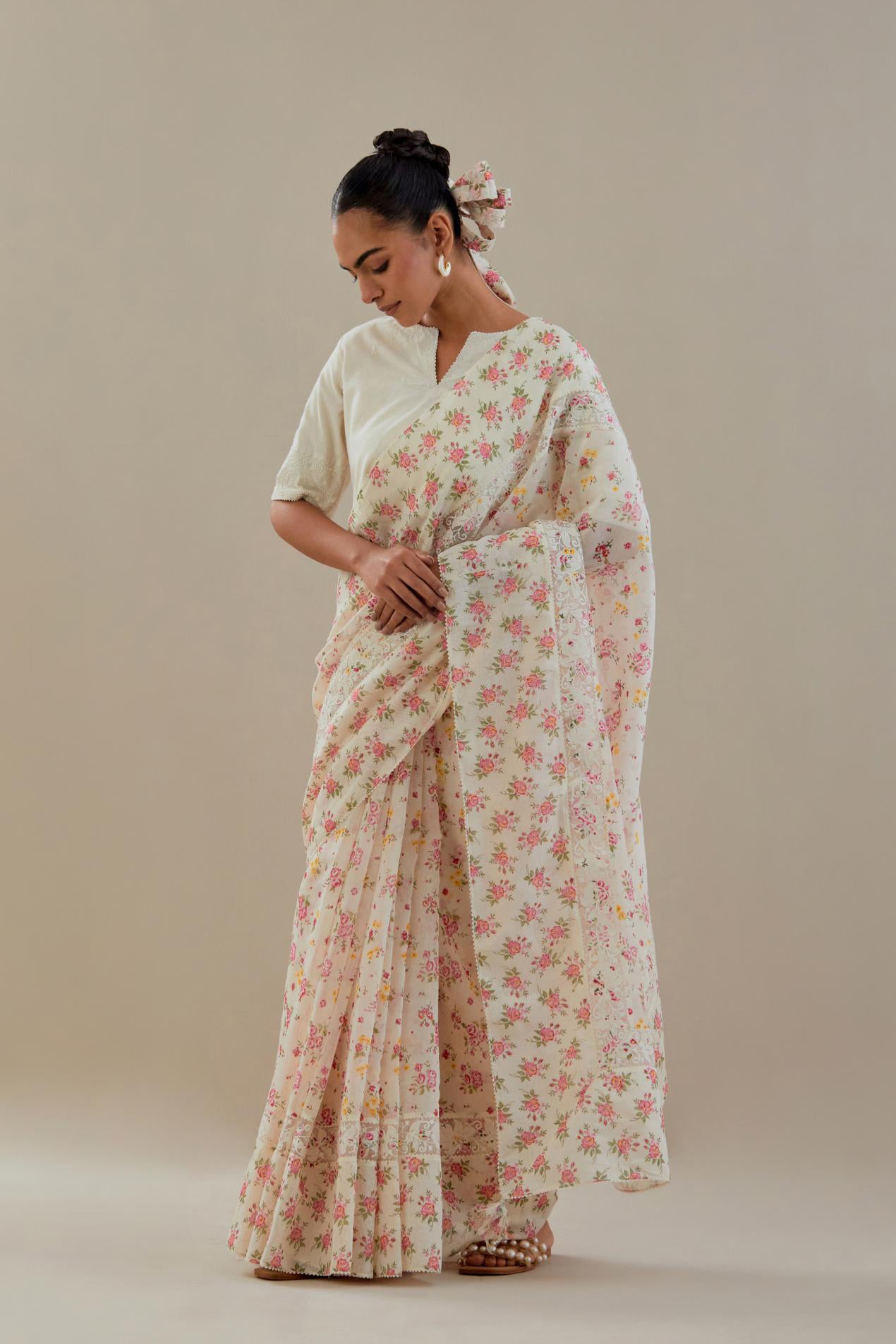 Off white cotton chanderi saree, highlighted with all-over small multi colored floral hand block print, highlighted with ricrac lace & applique, paired with off-white cotton blouse with thread embroidery & bead work.