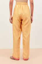 Yellow silk chanderi straight pants detailed with multi colored applique, highlighted with sequins work at bottom hem.