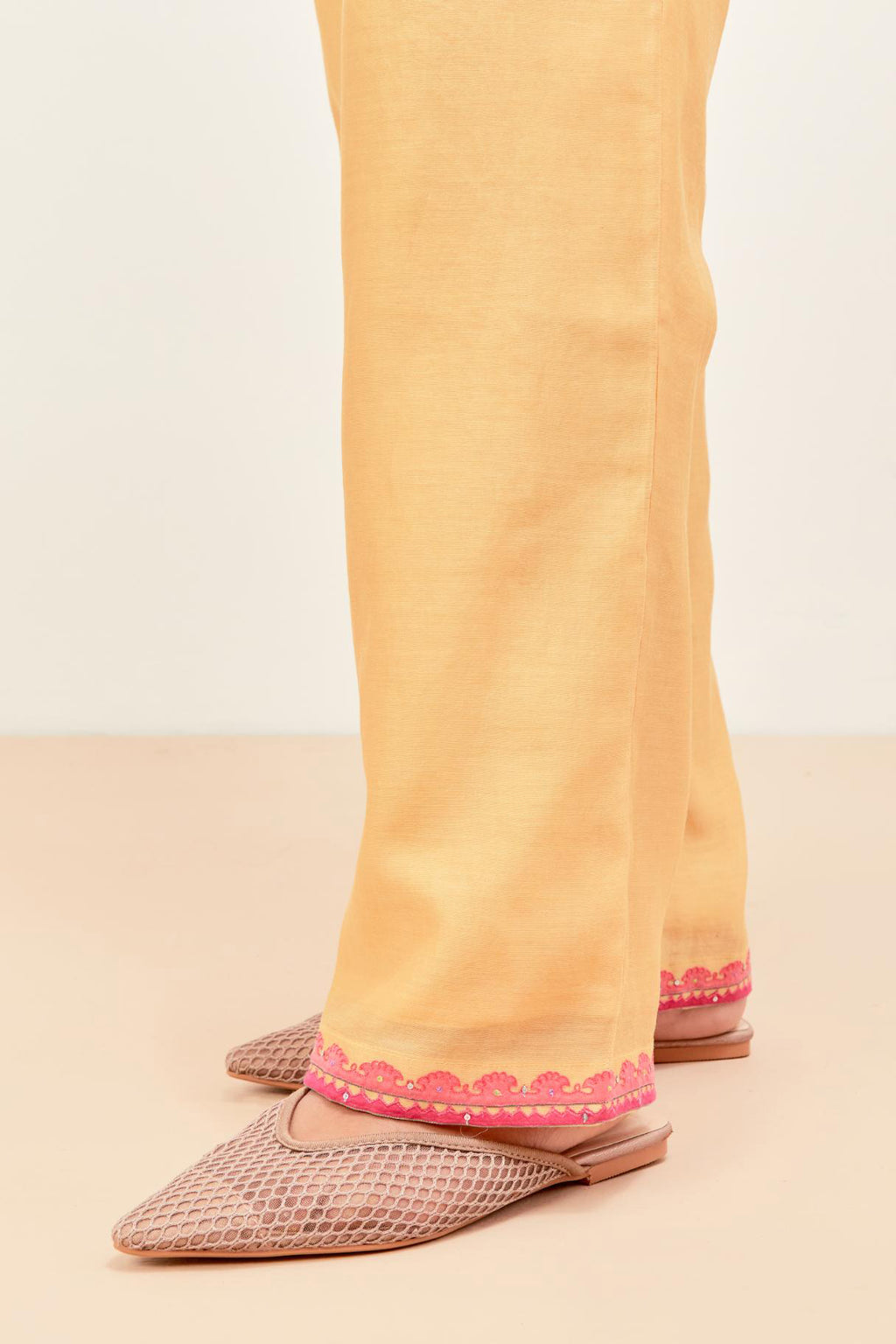 Yellow silk chanderi straight pants detailed with multi colored applique, highlighted with sequins work at bottom hem.