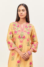 Yellow silk chanderi straight kurta set, decorated with appliqued jaal neckline and hem. The field has symmetrically placed bootas.
