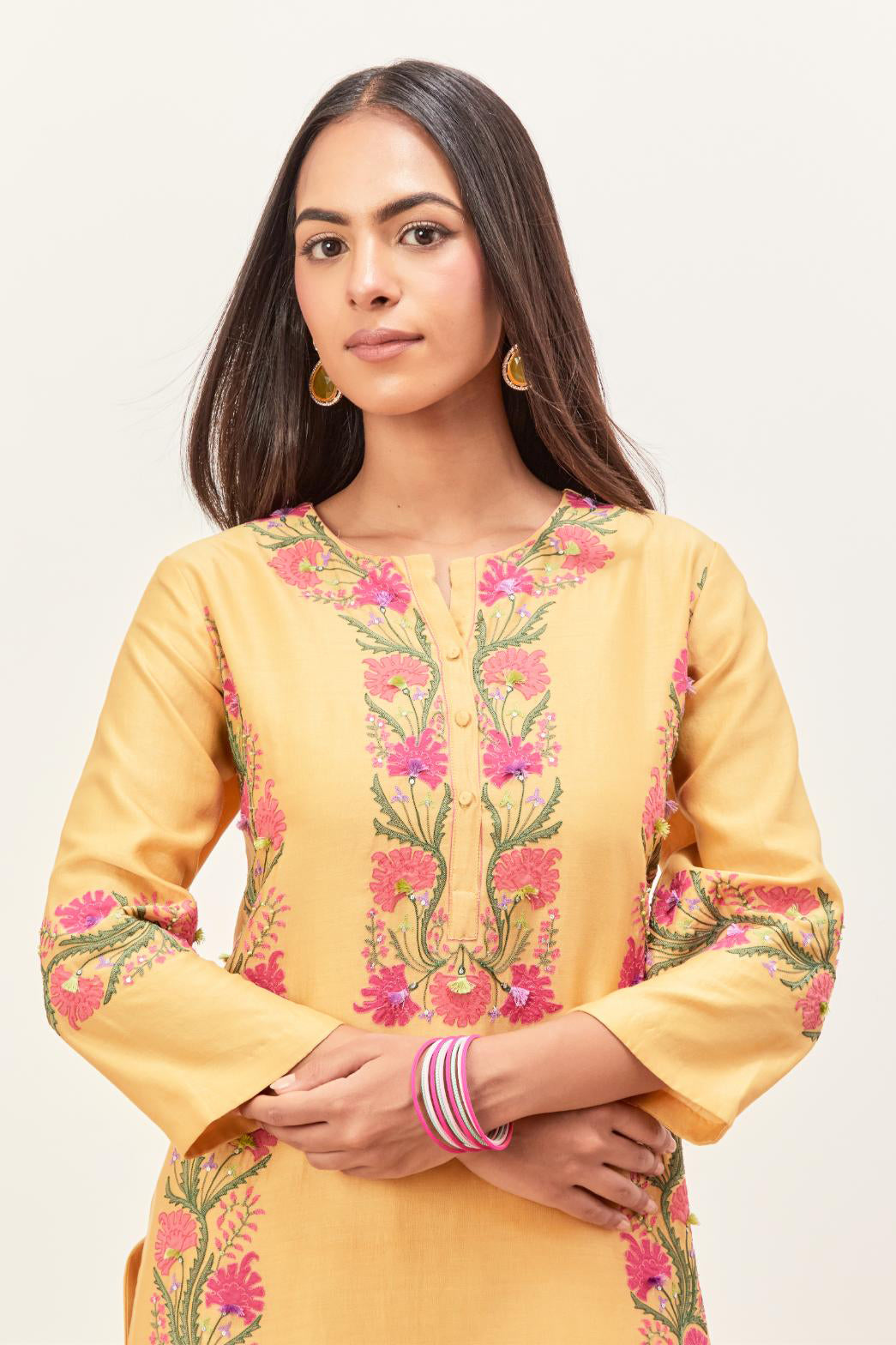 Yellow silk chanderi straight kurta set, decorated with appliqué borders along the side panels, neck and sleeves.