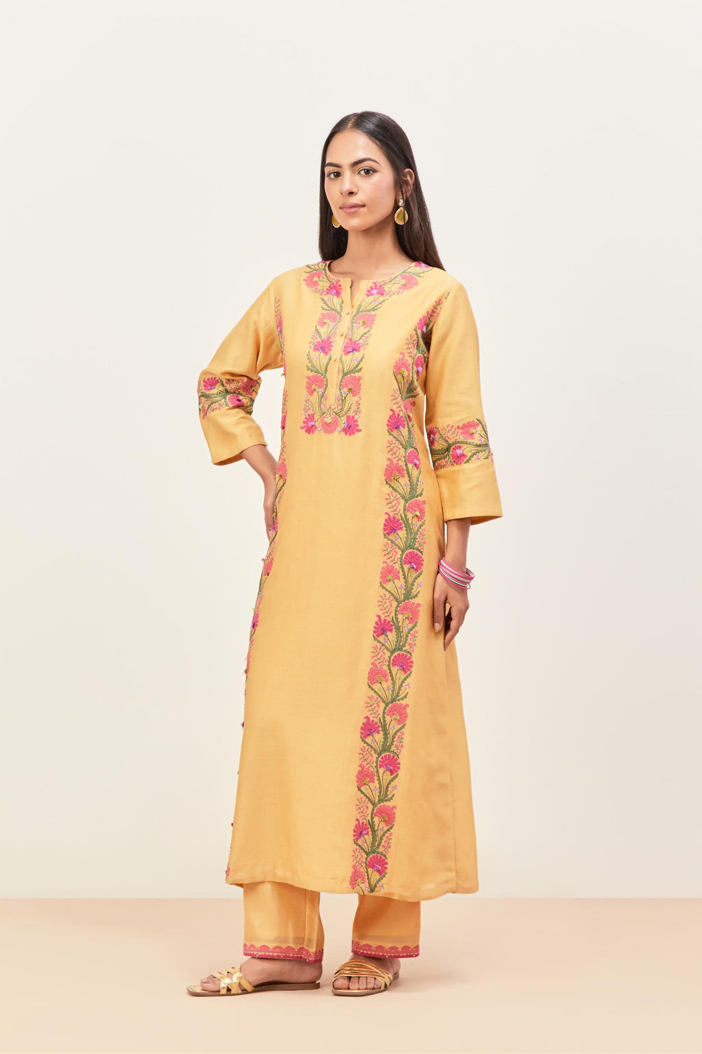 Yellow silk chanderi straight kurta set, decorated with appliqué borders along the side panels, neck and sleeves.