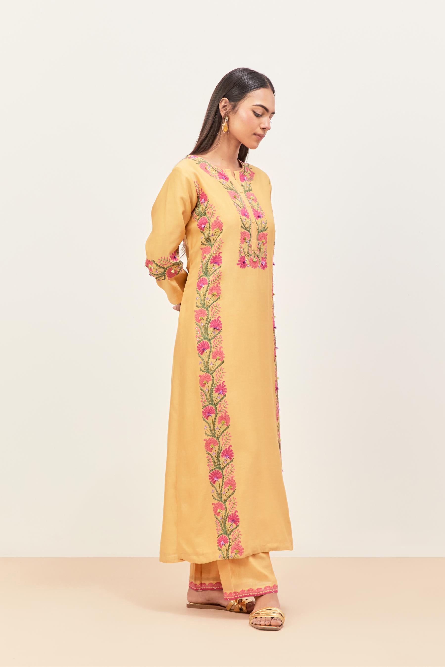 Yellow silk chanderi straight kurta set, decorated with appliqué borders along the side panels, neck and sleeves.