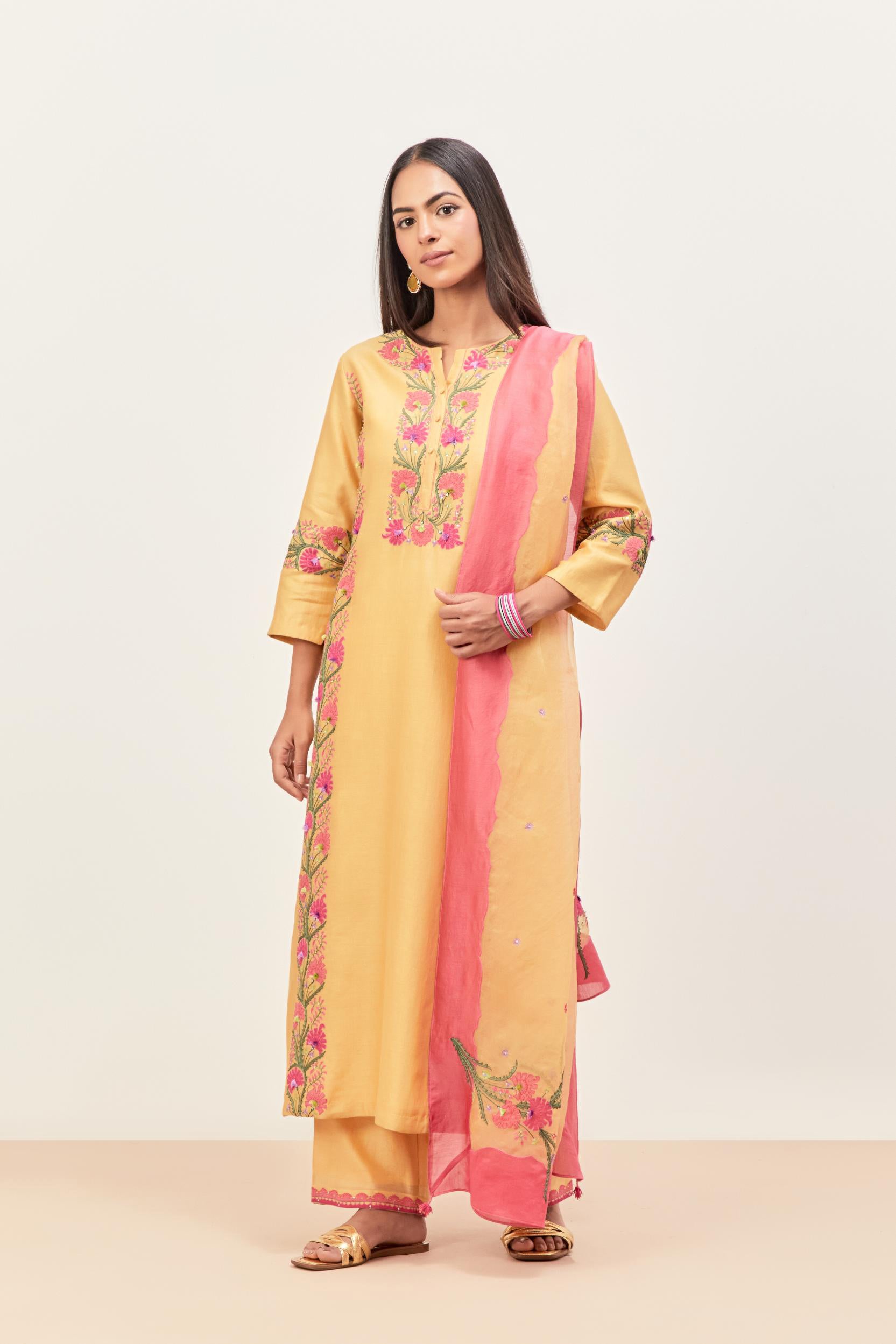 Yellow silk chanderi straight kurta set, decorated with appliqué borders along the side panels, neck and sleeves.