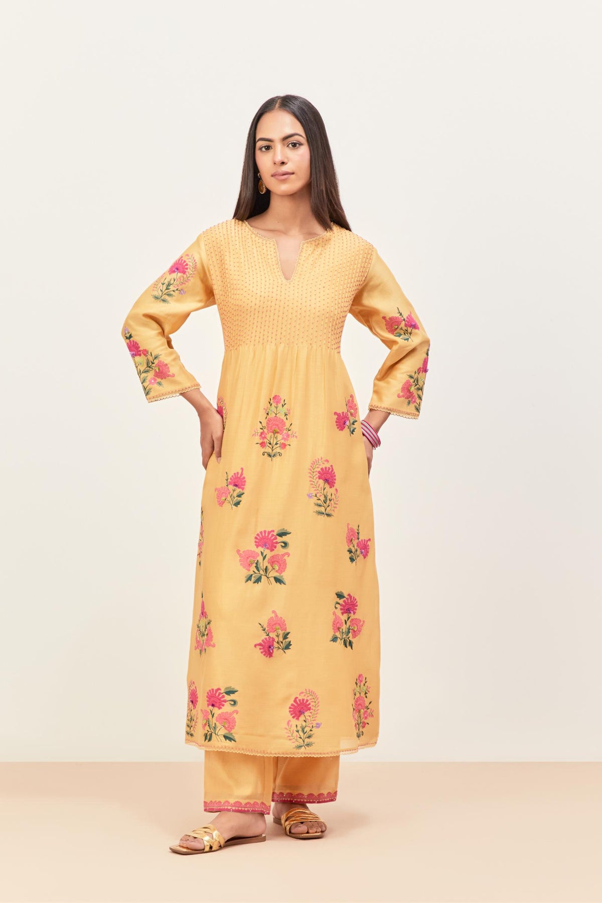 Yellow silk chanderi kurta set with pin tucks at yoke and all-over applique, highlighted with aari threadwork & sequins.