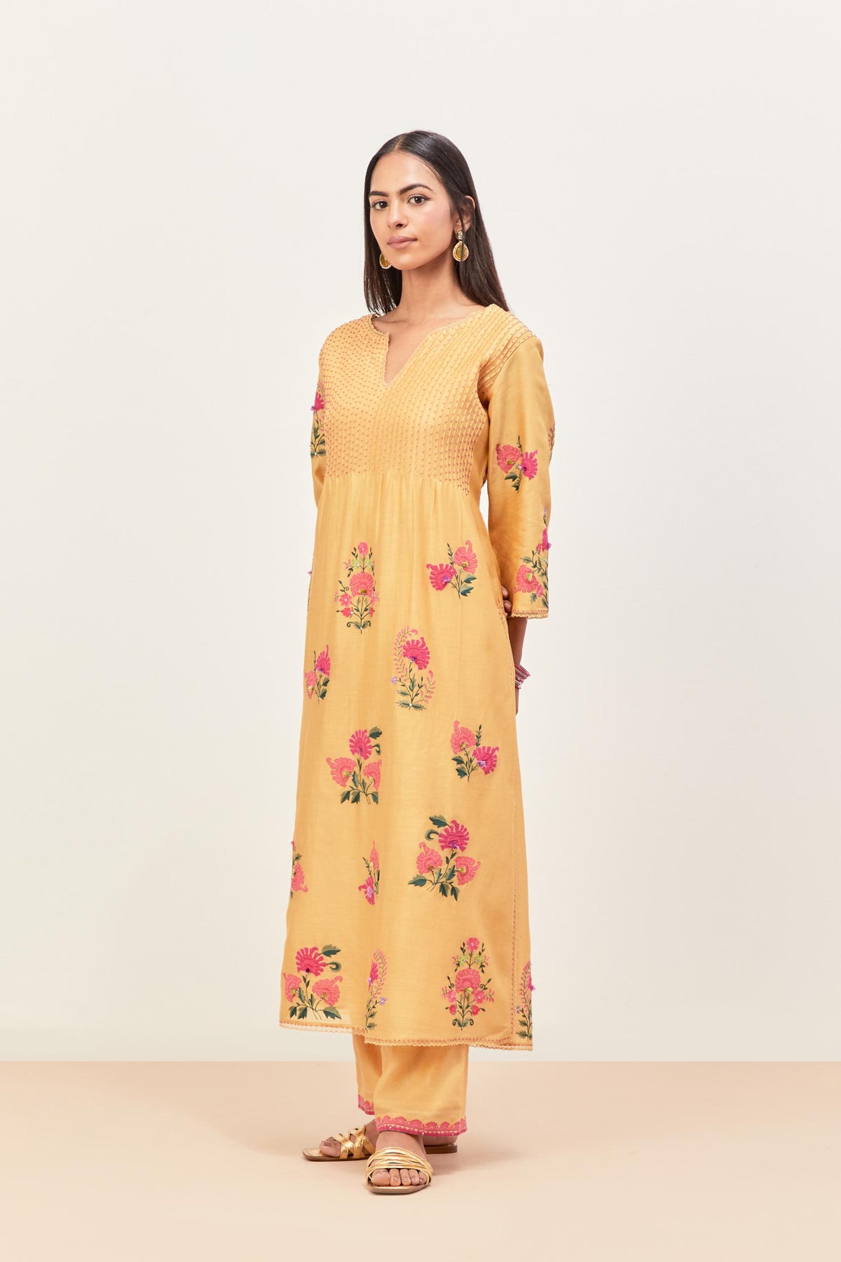 Yellow silk chanderi kurta set with pin tucks at yoke and all-over applique, highlighted with aari threadwork & sequins.