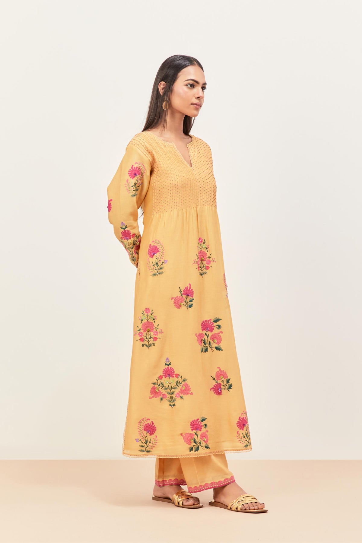 Yellow silk chanderi kurta set with pin tucks at yoke and all-over applique, highlighted with aari threadwork & sequins.