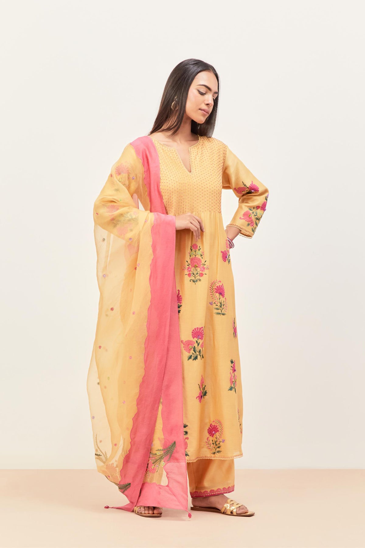 Yellow silk chanderi kurta set with pin tucks at yoke and all-over applique, highlighted with aari threadwork & sequins.
