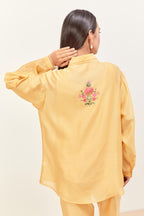 Yellow silk chanderi shirt with all-over pin tucks, highlighted with contrast beads in the front, paired with yellow silk chanderi straight pants detailed with multi colored applique, highlighted with sequins work at bottom hem.