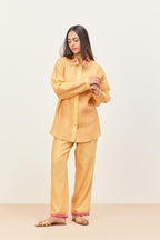 Yellow silk chanderi shirt with all-over pin tucks, highlighted with contrast beads in the front, paired with yellow silk chanderi straight pants detailed with multi colored applique, highlighted with sequins work at bottom hem.