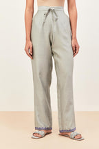 Bluish grey silk chanderi straight pants detailed with multi colored applique, highlighted with sequins work at bottom hem.
