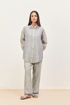 Bluish Grey silk chanderi shirt with all-over pin tucks, highlighted with contrast beads in the front, paired with Bluish Grey silk chanderi straight pants detailed with multi colored applique, highlighted with sequins work at bottom hem.