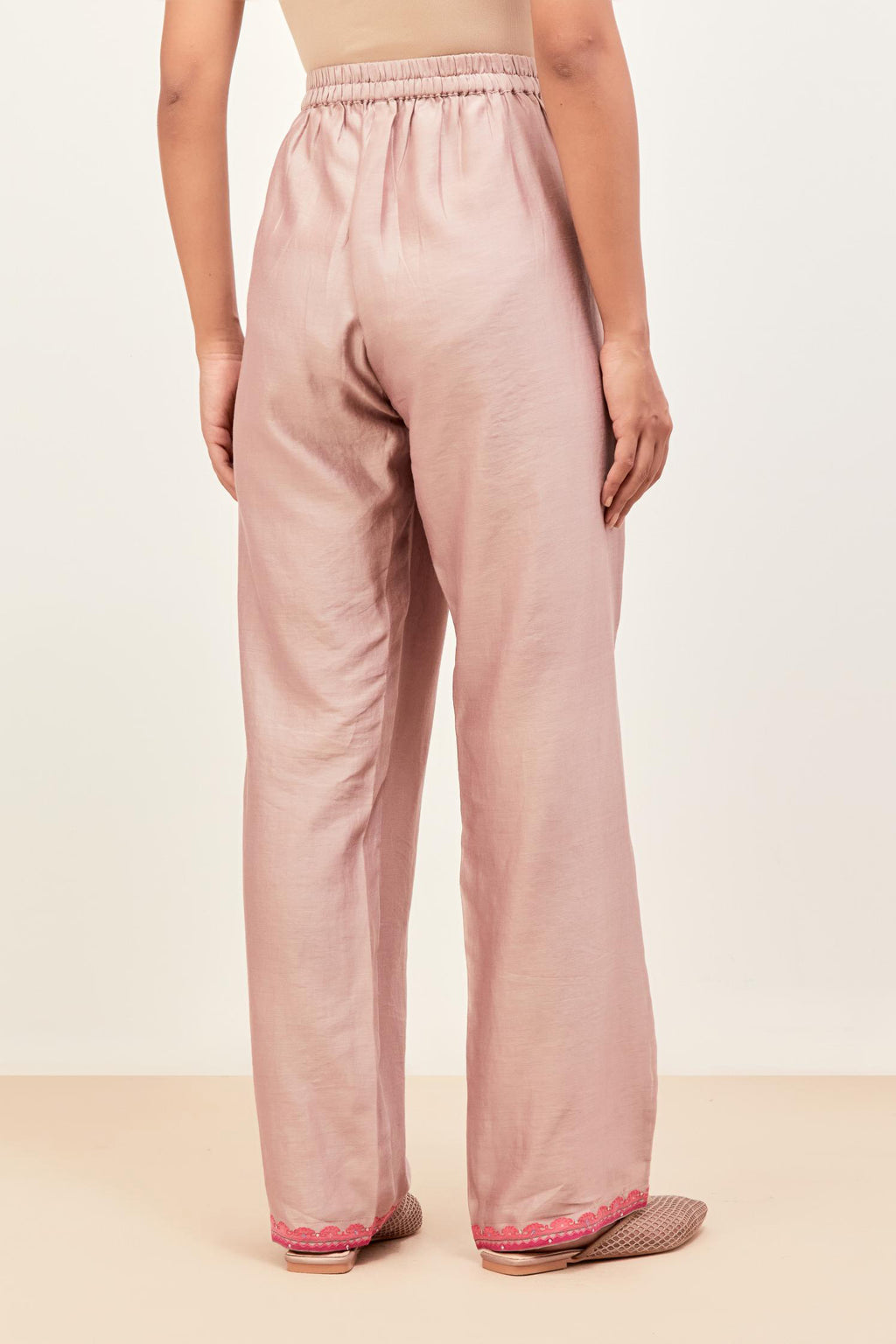 Lilac silk chanderi straight pants detailed with multi colored applique, highlighted with sequins work at bottom hem.