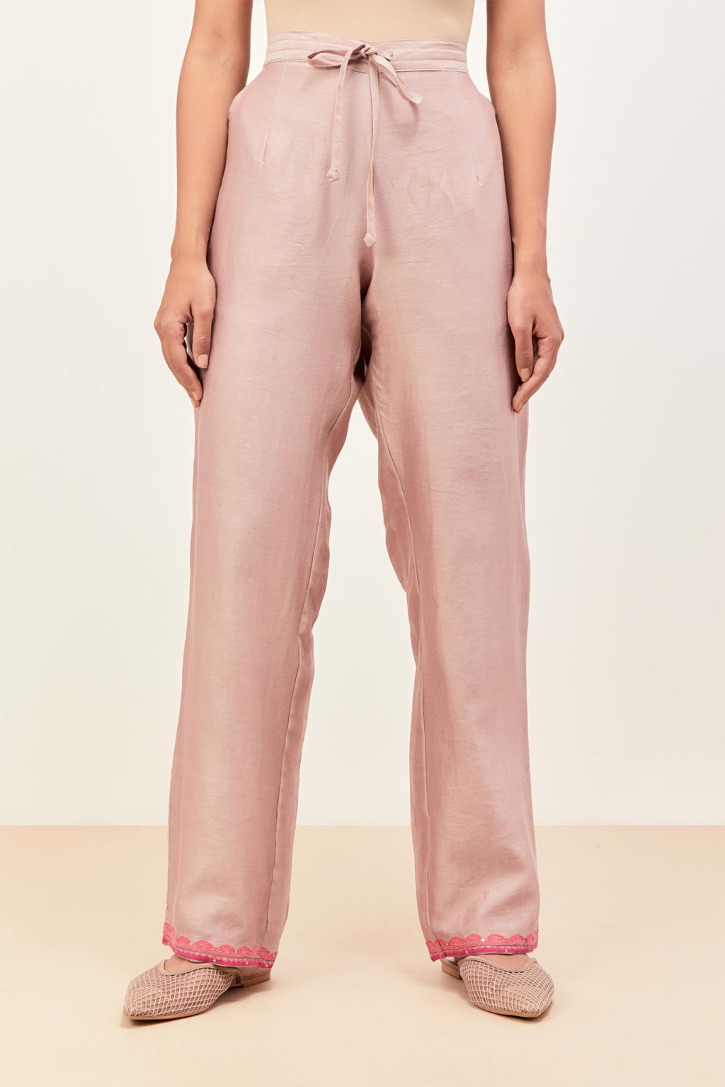 Lilac silk chanderi straight pants detailed with multi colored applique, highlighted with sequins work at bottom hem.