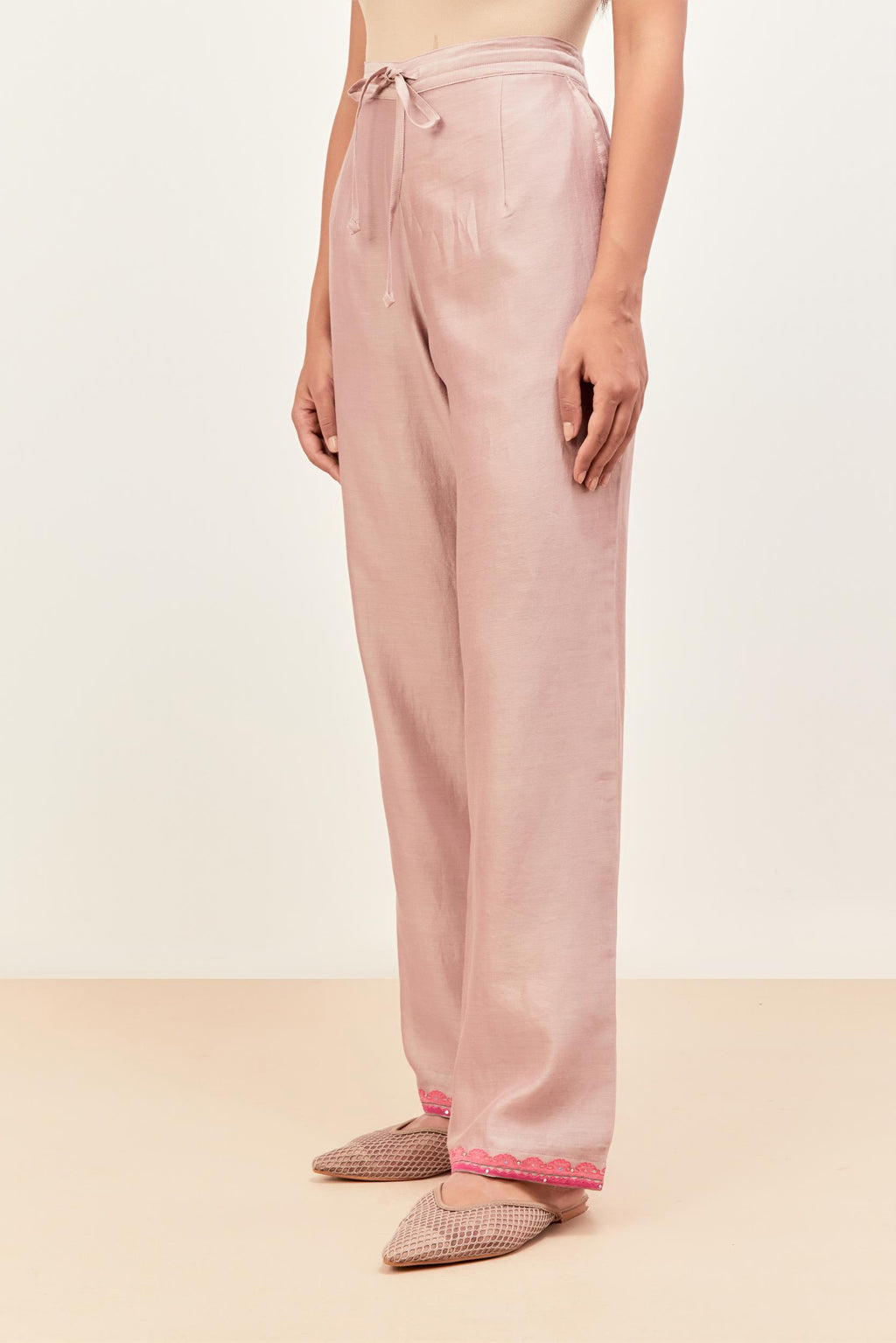 Lilac silk chanderi straight pants detailed with multi colored applique, highlighted with sequins work at bottom hem.