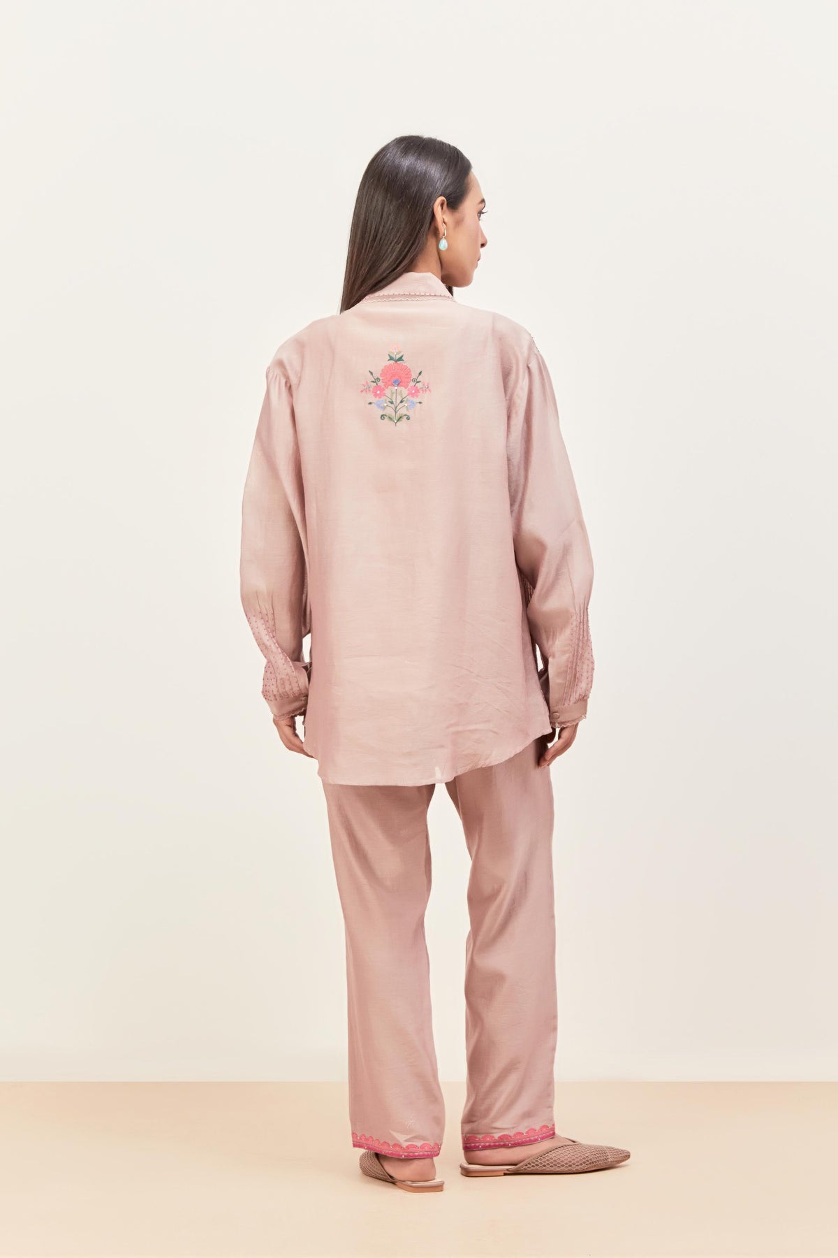 Lilac silk chanderi shirt with all-over pin tucks, highlighted with contrast beads in the front, paired with Lilac silk chanderi straight pants detailed with multi colored applique, highlighted with sequins work at bottom hem.