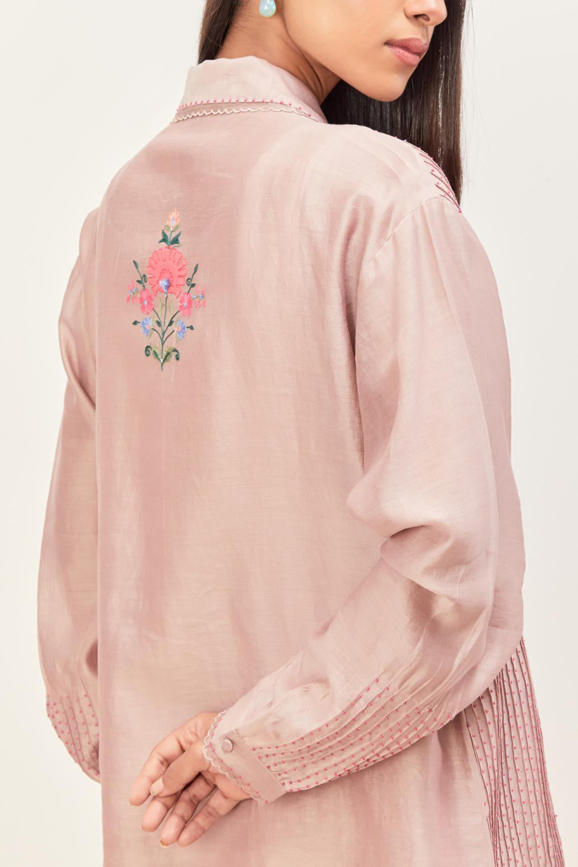 Lilac silk chanderi shirt with all-over pin tucks, highlighted with contrast beads in the front, paired with Lilac silk chanderi straight pants detailed with multi colored applique, highlighted with sequins work at bottom hem.