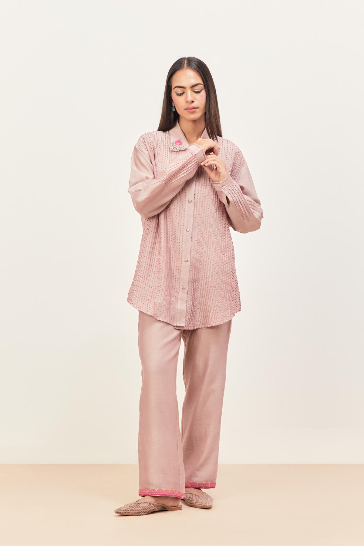 Lilac silk chanderi shirt with all-over pin tucks, highlighted with contrast beads in the front, paired with Lilac silk chanderi straight pants detailed with multi colored applique, highlighted with sequins work at bottom hem.