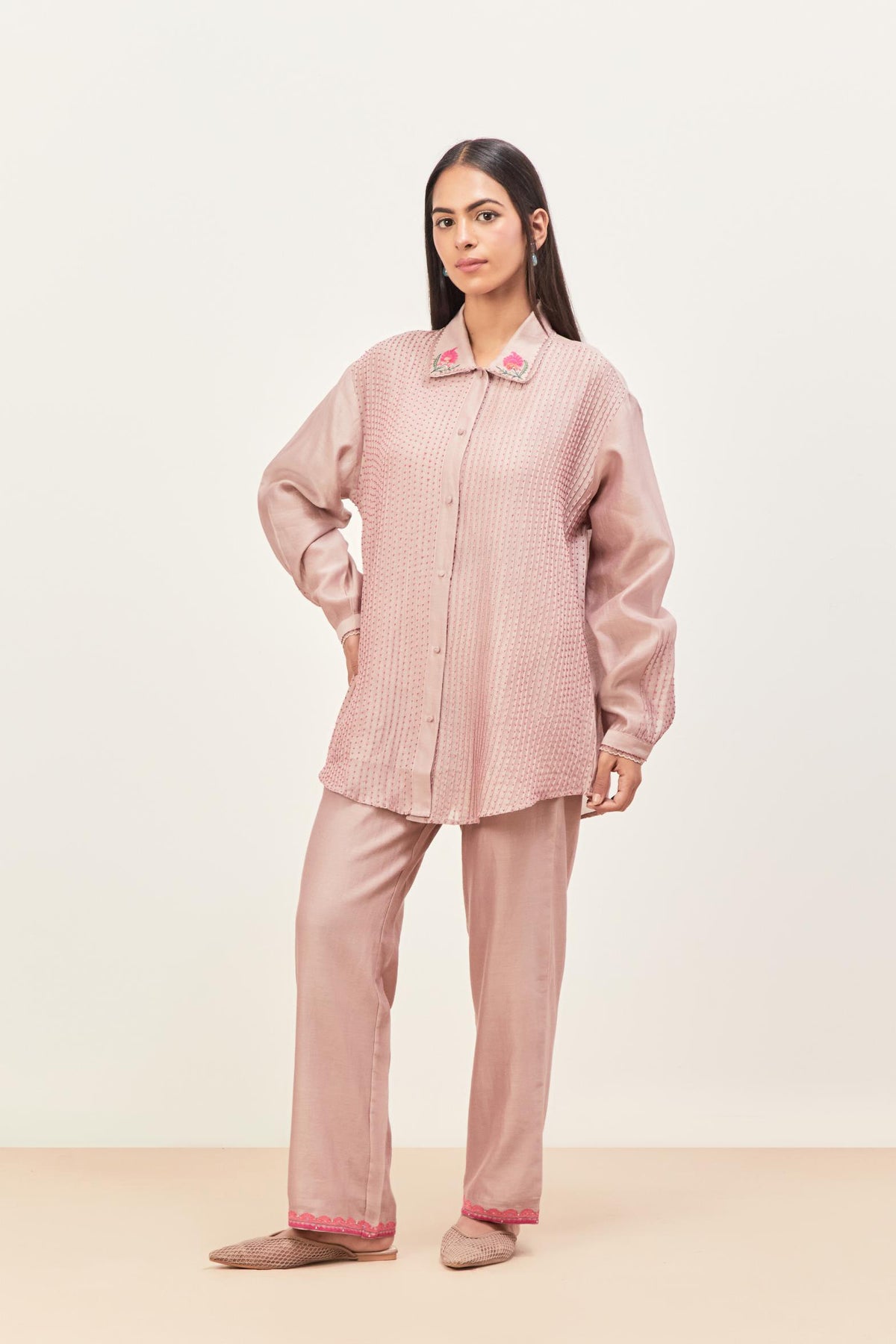 Lilac silk chanderi shirt with all-over pin tucks, highlighted with contrast beads in the front, paired with Lilac silk chanderi straight pants detailed with multi colored applique, highlighted with sequins work at bottom hem.