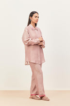 Lilac silk chanderi shirt with all-over pin tucks, highlighted with contrast beads in the front, paired with Lilac silk chanderi straight pants detailed with multi colored applique, highlighted with sequins work at bottom hem.