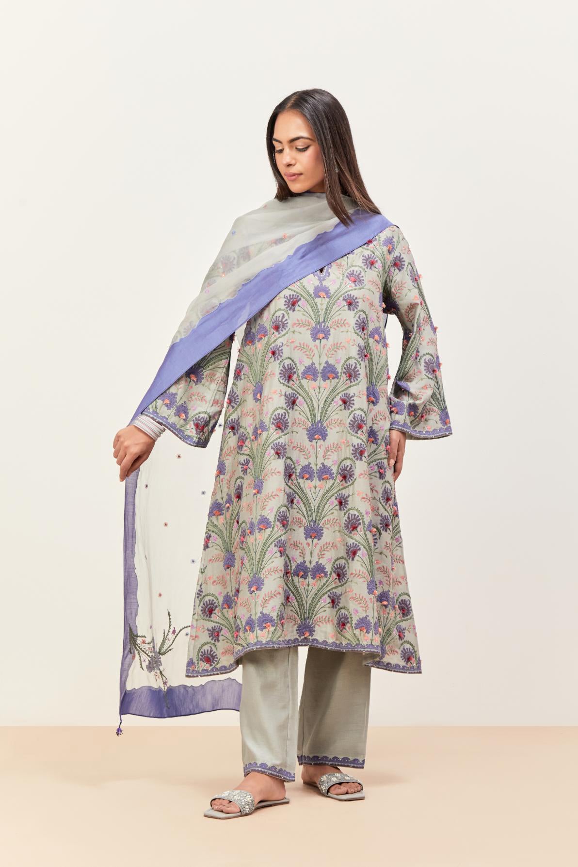 Bluish Grey short A-line silk chanderi kurta set, fully embroidered with appliqué flowers, highlighted with aari thread work and silk tassels.