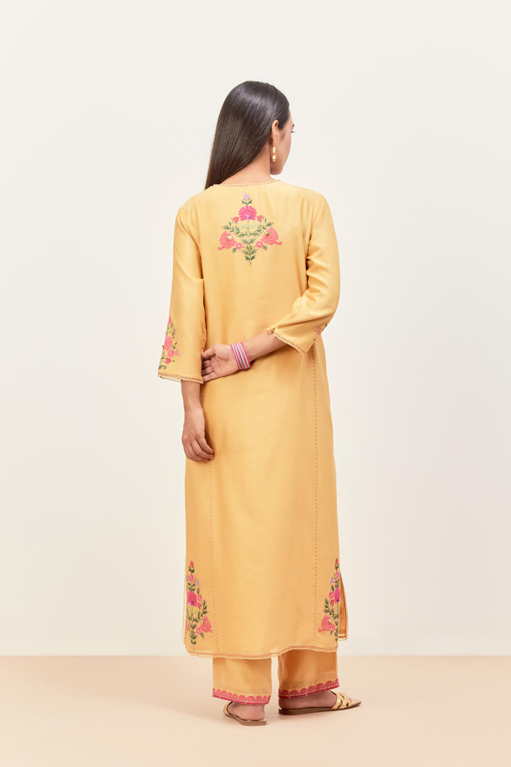 Yellow silk chanderi kurta set with pin tucks in the front & back and floral applique boota at sides, highlighted with aari threadwork & sequins.