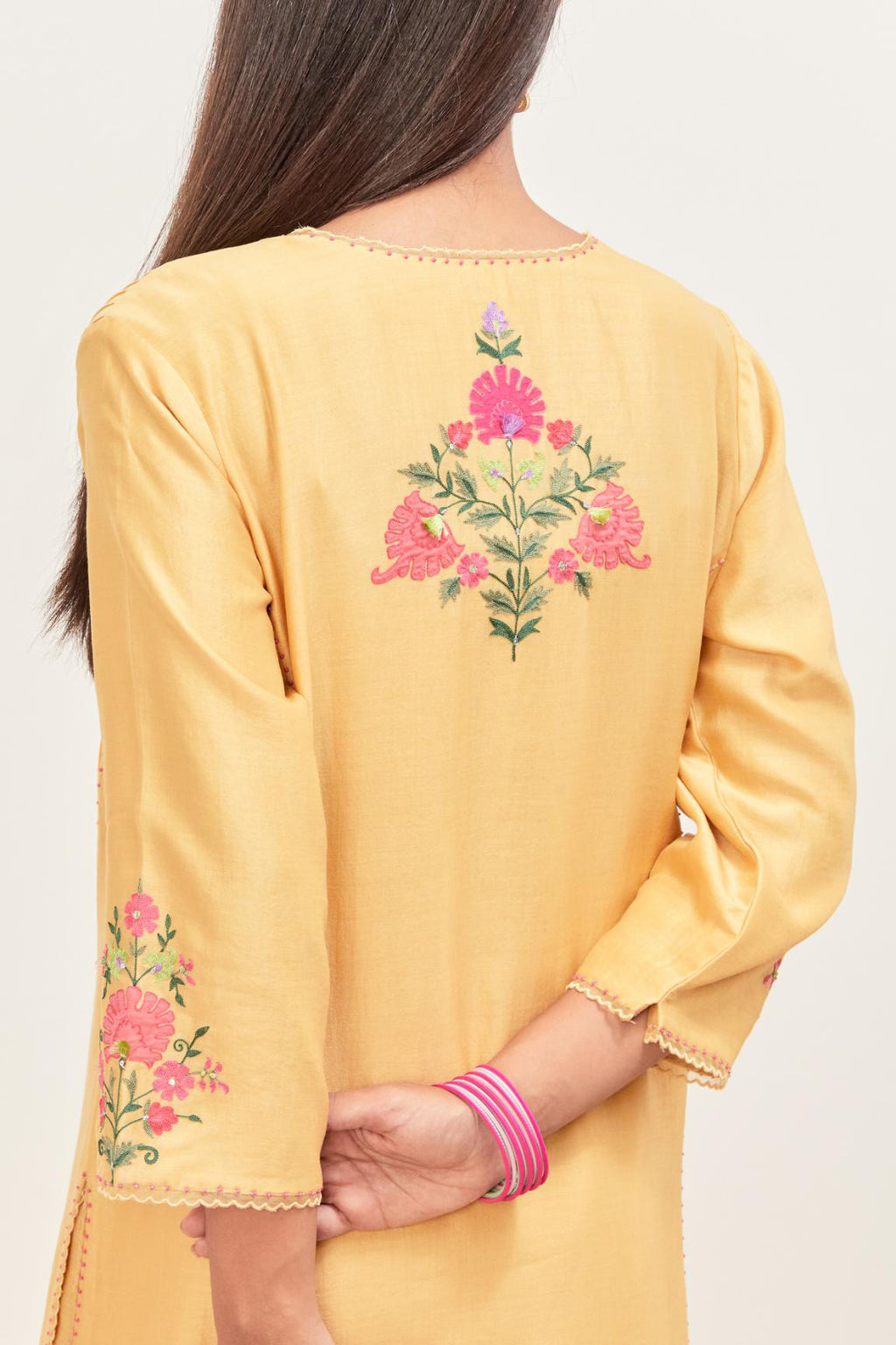 Yellow silk chanderi kurta set with pin tucks in the front & back and floral applique boota at sides, highlighted with aari threadwork & sequins.