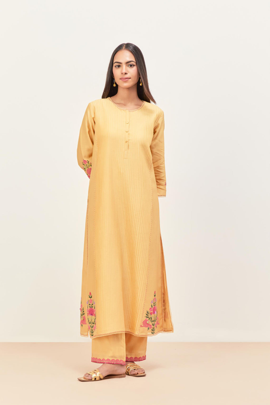 Yellow silk chanderi kurta set with pin tucks in the front & back and floral applique boota at sides, highlighted with aari threadwork & sequins.
