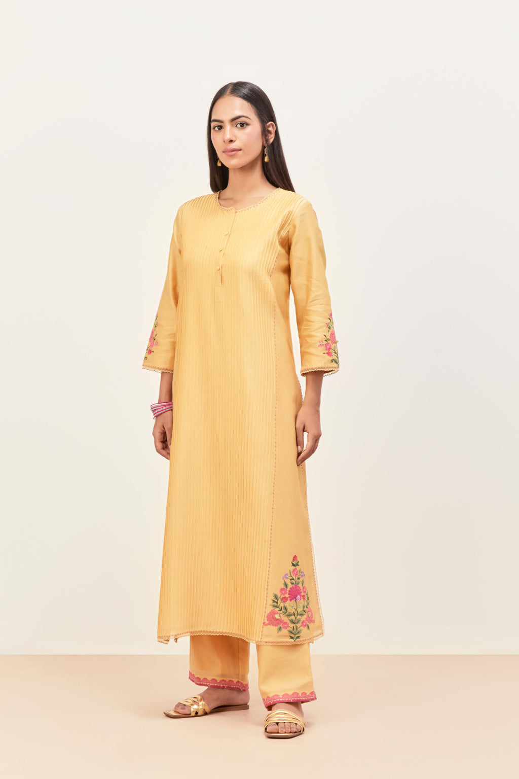Yellow silk chanderi kurta set with pin tucks in the front & back and floral applique boota at sides, highlighted with aari threadwork & sequins.