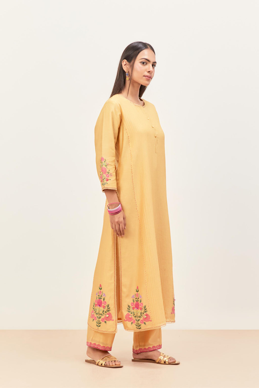 Yellow silk chanderi kurta set with pin tucks in the front & back and floral applique boota at sides, highlighted with aari threadwork & sequins.